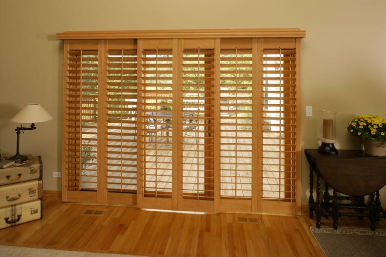 plantation shutters on sliding door leading to full porch.